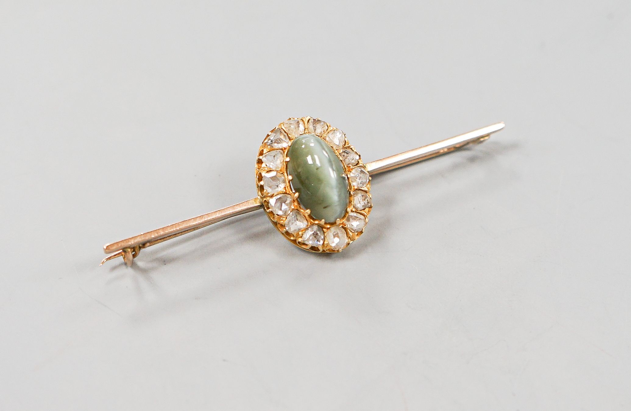 A yellow metal cat's eye chrysoberyl and rose cut diamond set bar brooch, 62mm, gross weight 6 grams.